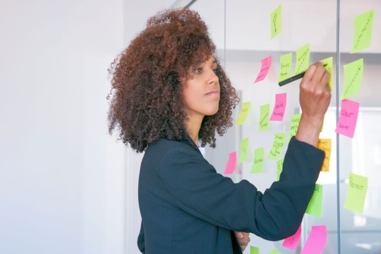 African American businesswoman writing on sticker with marker