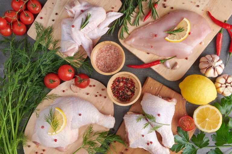 raw chicken fillet with garlic, pepper and rosemary on wooden on