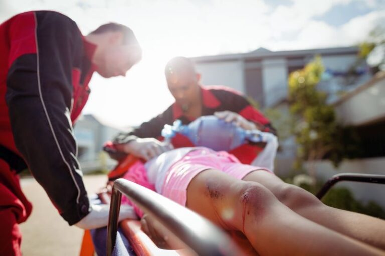 Paramedic giving oxygen to injured girl at accident spot